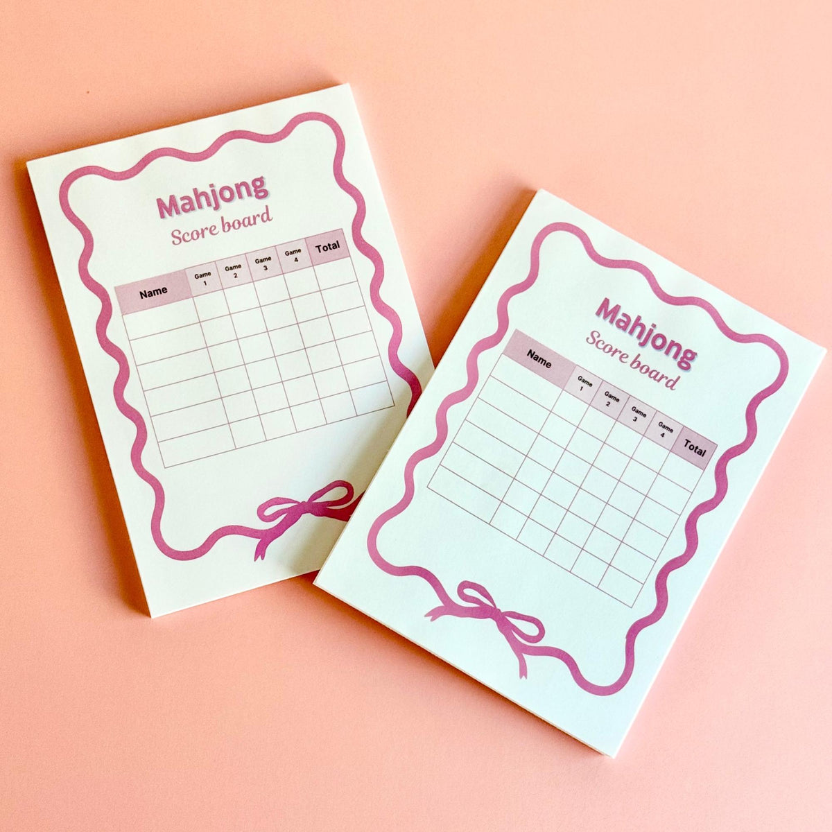 Mahjong scorecard notepads on a pink background