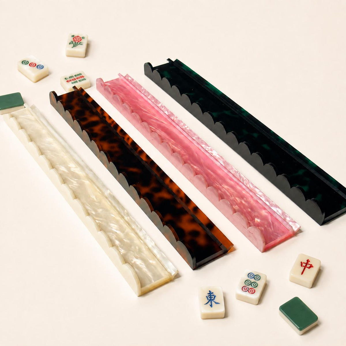 Four Mahjong tile racks in pearl, pink, tortoise and green tortoise
